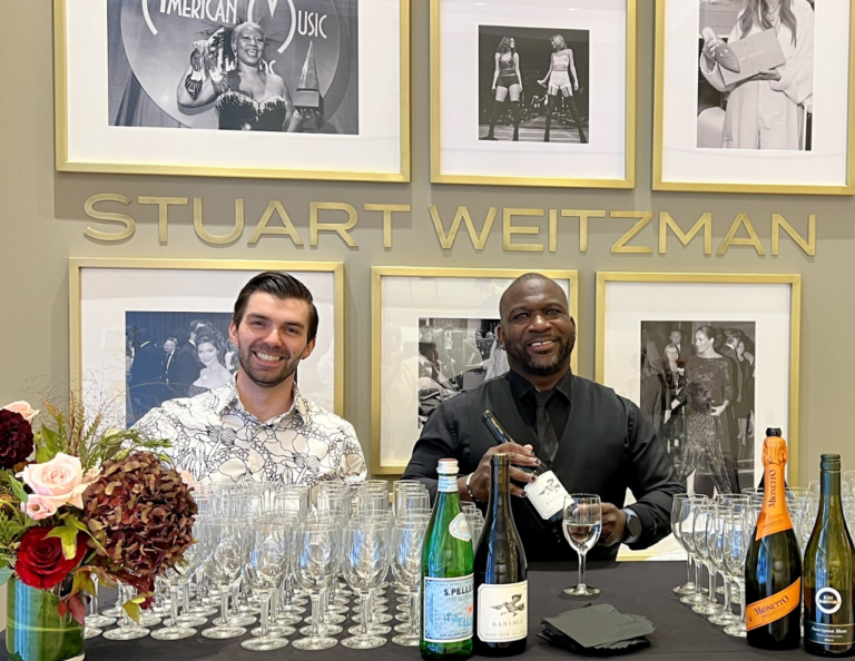 Sweet Basil Catering bartenders setting up a champagne and wine station at a Stuart Weitzman event in NYC, ready to welcome arriving guests.